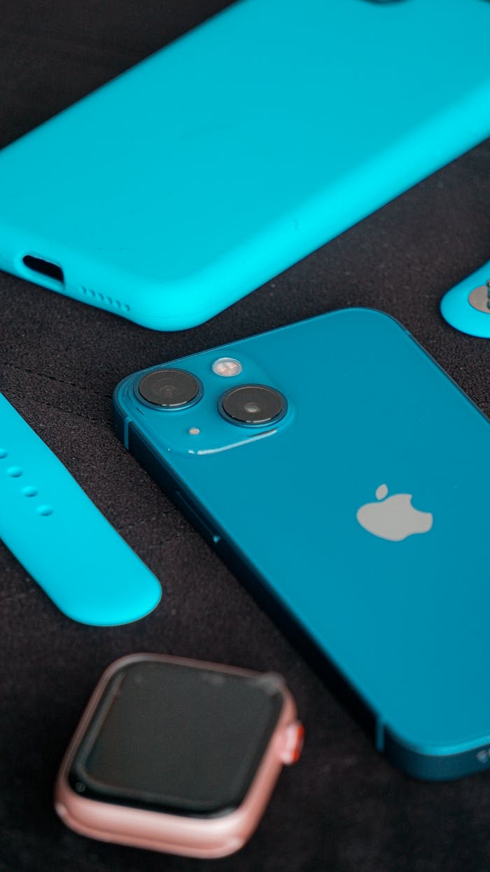 Close-up of a blue smartphone and accessories arranged on a black surface, showcasing modern technology.