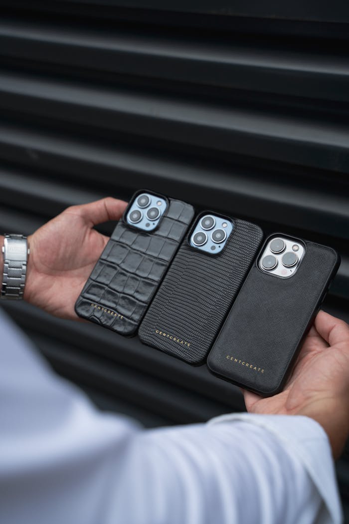 Premium leather smartphone cases held against a dark backdrop emphasizing luxury.